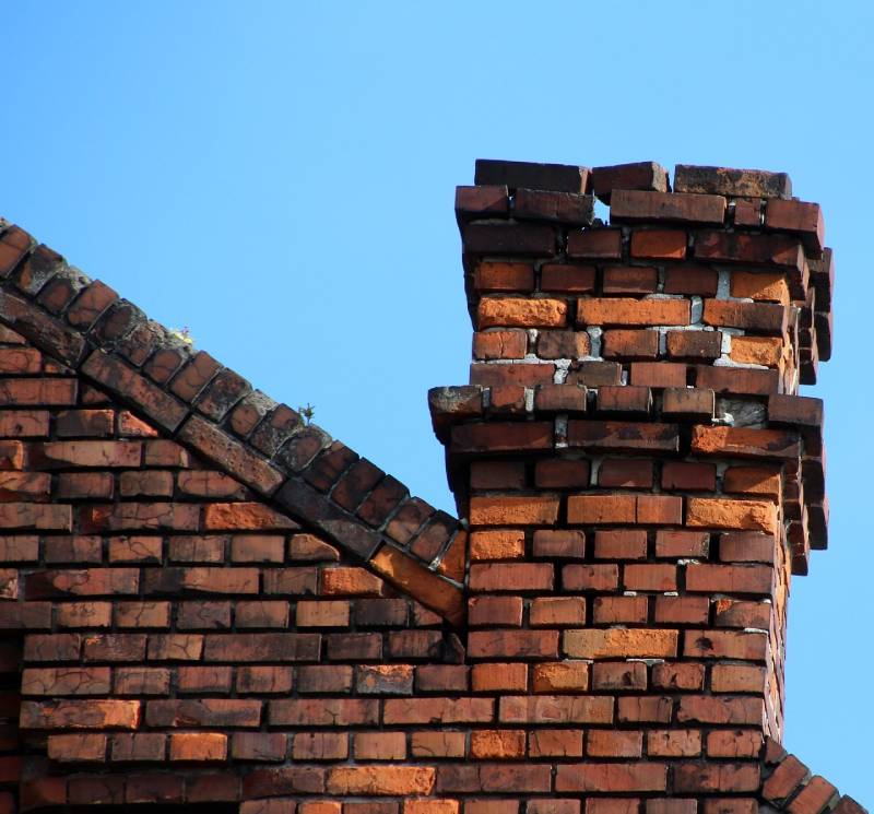 Damaged chimney on an Calverton home showing cracks and missing mortar